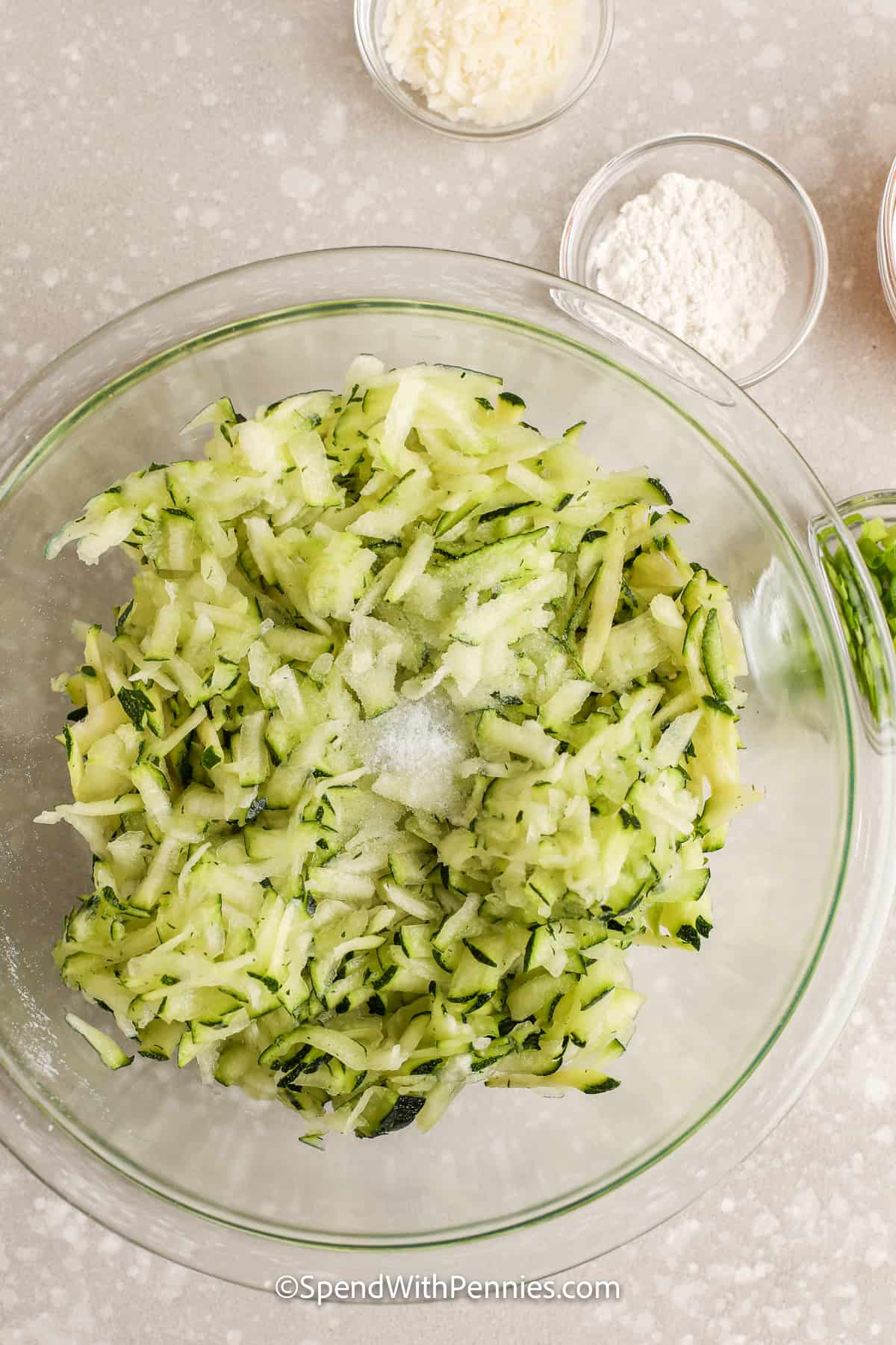 strimlad zucchini i en skål med salt på toppen