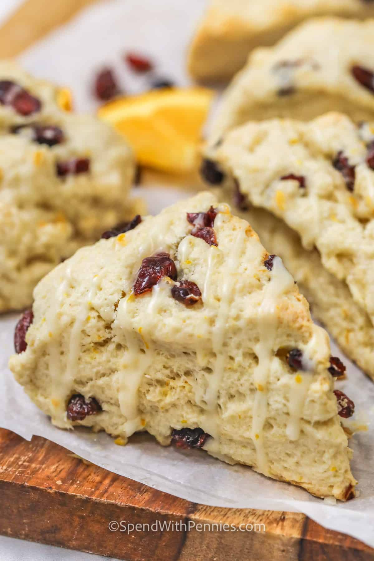 For a sweet treat that the chef will be pestered to make, again and again, try these yummy cranberry orange scones that are just as good as Starbucks! Feel free to enjoy them according to the recipe or use Bisquick or gluten free flour. Try making them with add-ins and subs. Scones turn out light and fluffy with the best orange glaze. And they freeze well for a make-and-take snack or easy breakfast. #cranberryorangescones #spendwithpennies #recipeeasy #orangecranberryscones close up of Cranberry Orange Scones