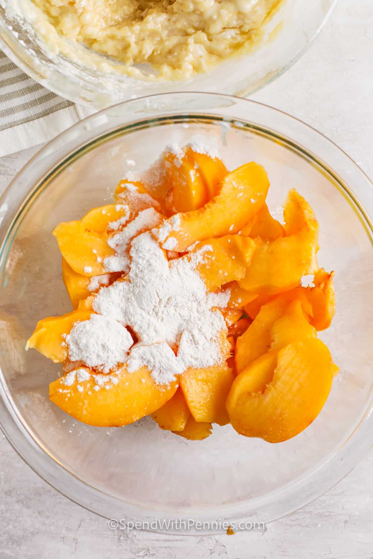 Fresh peaches combine with a brown sugar and cinnamon glaze to top a fluffy moist cake in this recipe for peach upside down cake. You can also use canned or frozen peaches with great results. Sliced peaches are baked with a yellow cake batter to make this irresistible treat. Bake it in a cake pan or even a cast iron skillet for a touch of rustic charm. Swap out the peaches for other fruits, like apple, pineapple, and even blueberry. #spendwithpennies flour added to peaches to make Peach Upside Down Cake