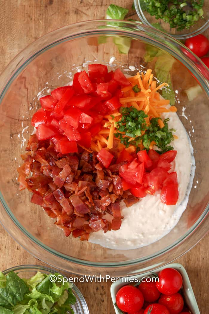 This easy BLT dip recipe is made with creamy ingredients like sour cream, cream cheese, and mayo! With crispy bacon, tomatoes, lettuce, and shredded cheese on top, it tastes just like a BLT, minus the bread! It is best served cold with an assortment of dippers like veggies, crackers, or even breadsticks. #bltdip #colddip #appetizer #spendwithpennies BLT Dip ingredients in a glass bowl
