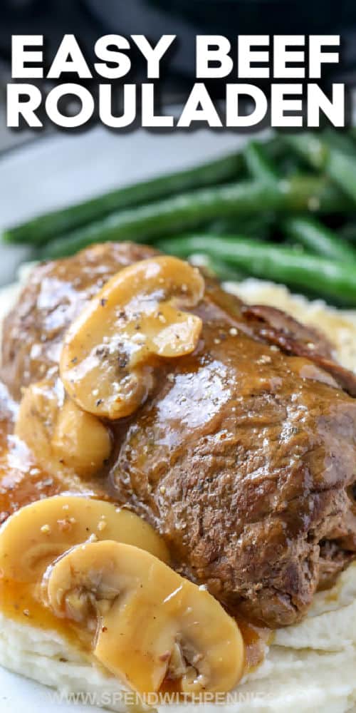 Make this easy Rouladen recipe in the oven or in the slow cooker. Start with thinly sliced inside round or flank steak and cover it in mustard, onions, bacon and wrap around a dill pickle! This classic German recipe is so delicious and well worth the wait! #spendwithpennies #rouladen #maincourse #beefrecipe Beef Rouladen with mushrooms and mashed potatoes with a title