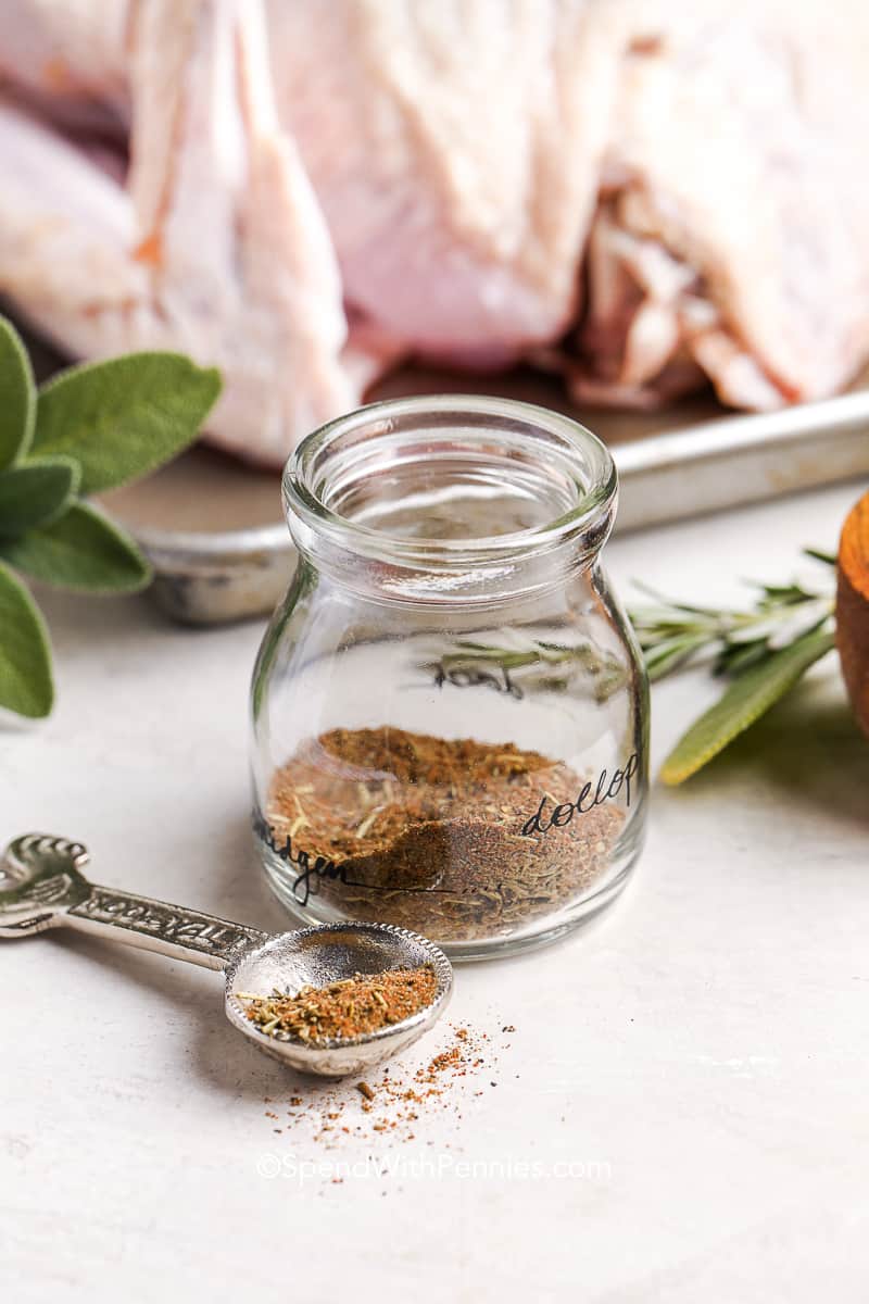 a jar of homemade turkey seasoning with a turkey in the background