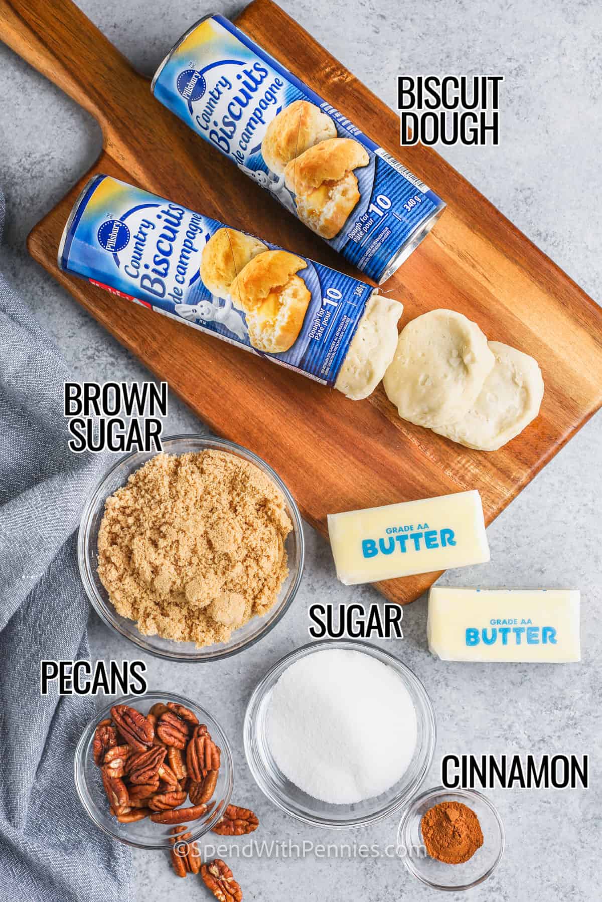 Light and fluffy monkey bread with cinnamon and pecans is a fun way to feed a crowd at breakfast. Everybody just pulls it apart! Biscuit dough from a can or homemade is rolled into balls, coated with butter, and tossed with cinnamon sugar. Then they are layered in a Bundt pan with chopped pecans, and baked until golden brown and coated with a sticky glaze. #monkeybread #spendwithpennies #monkeybreadrecipe #monkeybreadwithcannedbiscuits biscuit dough , brown sugar , butter , sugar , cinnamon and pecans with labels to make Monkey Bread