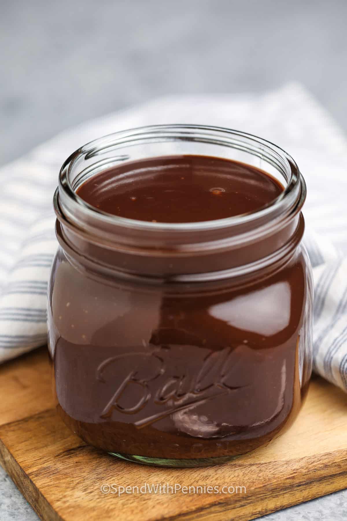 Flavorful and sweet, fudge sauce is best served with all kinds of desserts, from brownies to cakes and ice cream to homemade hot fudge sundaes. This easy recipe is ready in 5 minutes and so easy to make with just 5 simple ingredients! Heat it up on the stove in no time and serve it up for special treats. It's creamy, chocolaty, and always a favorite. #homemadehotfudgesauce #easyhotfudgesauce #fudgesauce #spendwithpennies Jar of fudge sauce