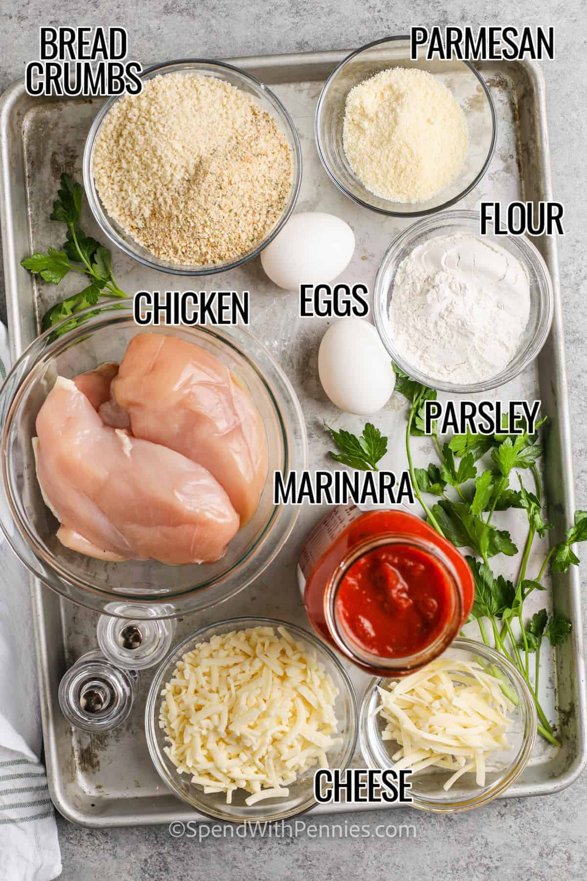 Try this easy chicken parmesan recipe for your next tasty dinner. With crispy breaded chicken breasts, marinara sauce, and melted cheese, it’s sure to be a family favorite. Preheat your oven, coat and brown the chicken, then bake with marinara and cheese until bubbly. Serve over pasta, garnished with fresh basil and parsley. It’s perfect for a weeknight meal or a special occasion. #spendwithpennies bread crumbs , parmesan , flour , eggs , chicken , marinara sauce , parsley and cheese with labels to make Easy Chicken Parmesan