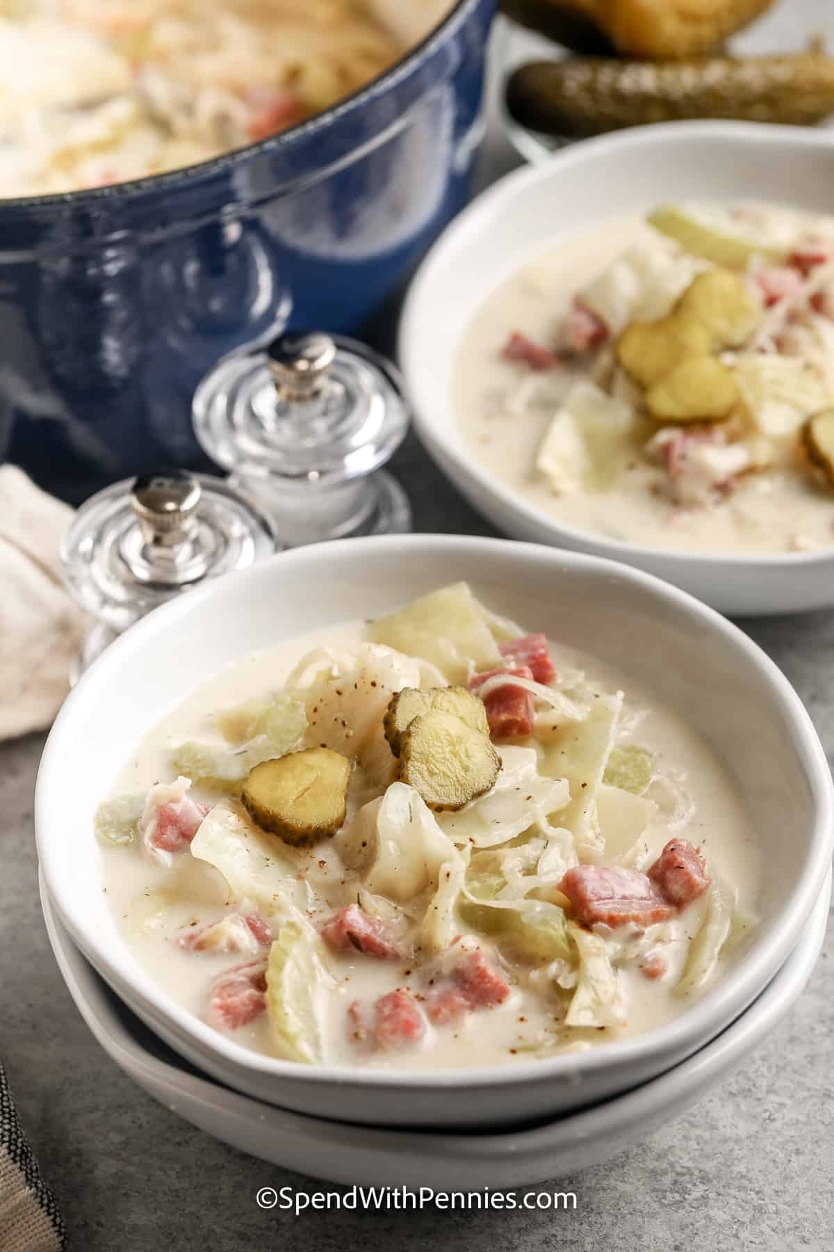 This recipe for creamy Reuben soup is the perfect meal in a bowl, especially if you have leftover corned beef! Cabbage, corned beef, and sauerkraut are cooked with caraway seeds, mustard, and other seasonings in a creamy broth. Shredded Swiss cheese is swirled in at the end. Serve this delicious soup with rye or pumpernickel croutons. Tastes as great as the classic sandwich! #reubensoup #spendwithpennies #reubensoupwithcabbage #reubensouprecipe reuben soup in a bowl