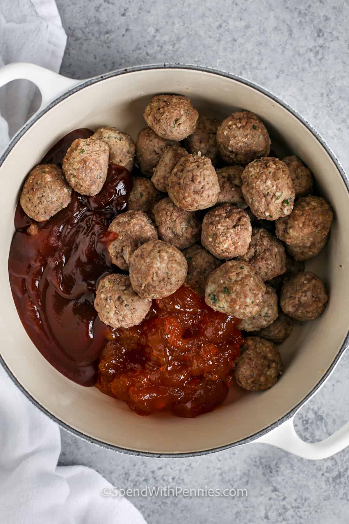 Who doesn’t love cocktail meatballs? This recipe makes the best sweet and sour meatballs, with a smoky slow cooked flavor. Just place precooked frozen meatballs in a saucepan or crock pot with apricot preserves and barbecue sauce and heat until melted and bubbling hot. For variety, substitute grape jelly or cranberry sauce. #cocktailmeatballs #spendwithpennies #bestcocktailmeatballsrecipe #sweetandsourmeatballswithjelly adding ingredients to pot to make Sweet and Sour Meatballs