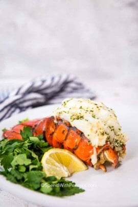 lobster tail on a plate with lettuce and lemon