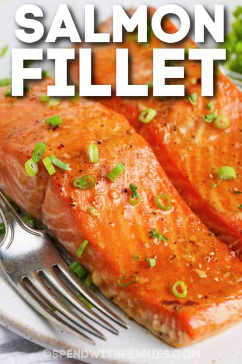 Baked salmon fillets are a great weeknight meal! Made by marinating fresh salmon fillets in a homemade orange glaze, then oven-baked for the perfect flaky texture! #bakedsalmon #salmonmarinade #easyrecipe #spendwithpennies Baked Salmon Fillets on a plate with a fork and a title