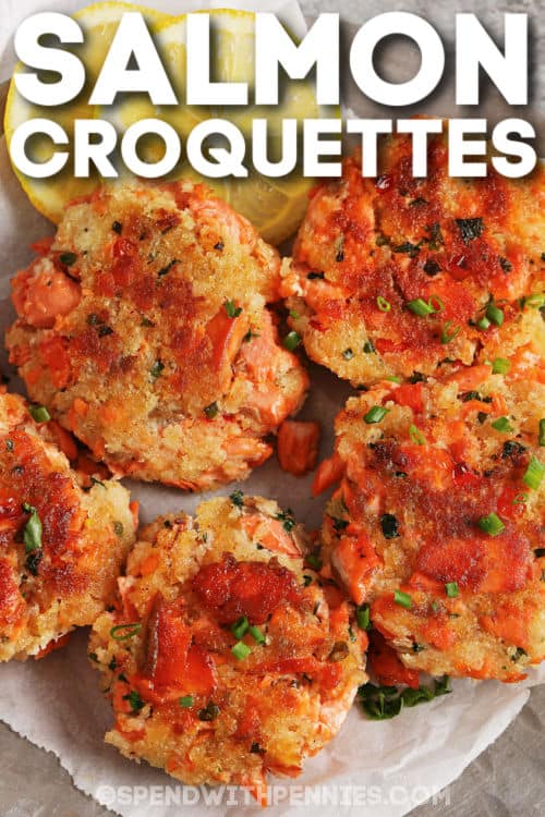 This salmon croquette recipe is delicious whether baked or fried! Made with salmon, mayonnaise, panko, and herbs, they are shaped into patties and baked or pan-fried until golden brown. Perfectly crispy on the outside and flavorful on the inside, serve as an appetizer or as a light meal with a simple side salad. #salmoncroquettes #baked #easy #salmon #spendwithpennies plated Salmon Croquettes with a lemon slice