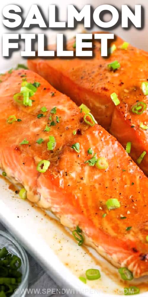 Marinated in a homemade ginger orange glaze, these baked salmon fillets are full of flavor and perfectly tender and flaky! Great for an elegant dinner party but easy enough for any night of the week! #bakedsalmon #salmonmarinade #easyrecipe #spendwithpennies close up of Baked Salmon Fillets cooked in a dish with a title