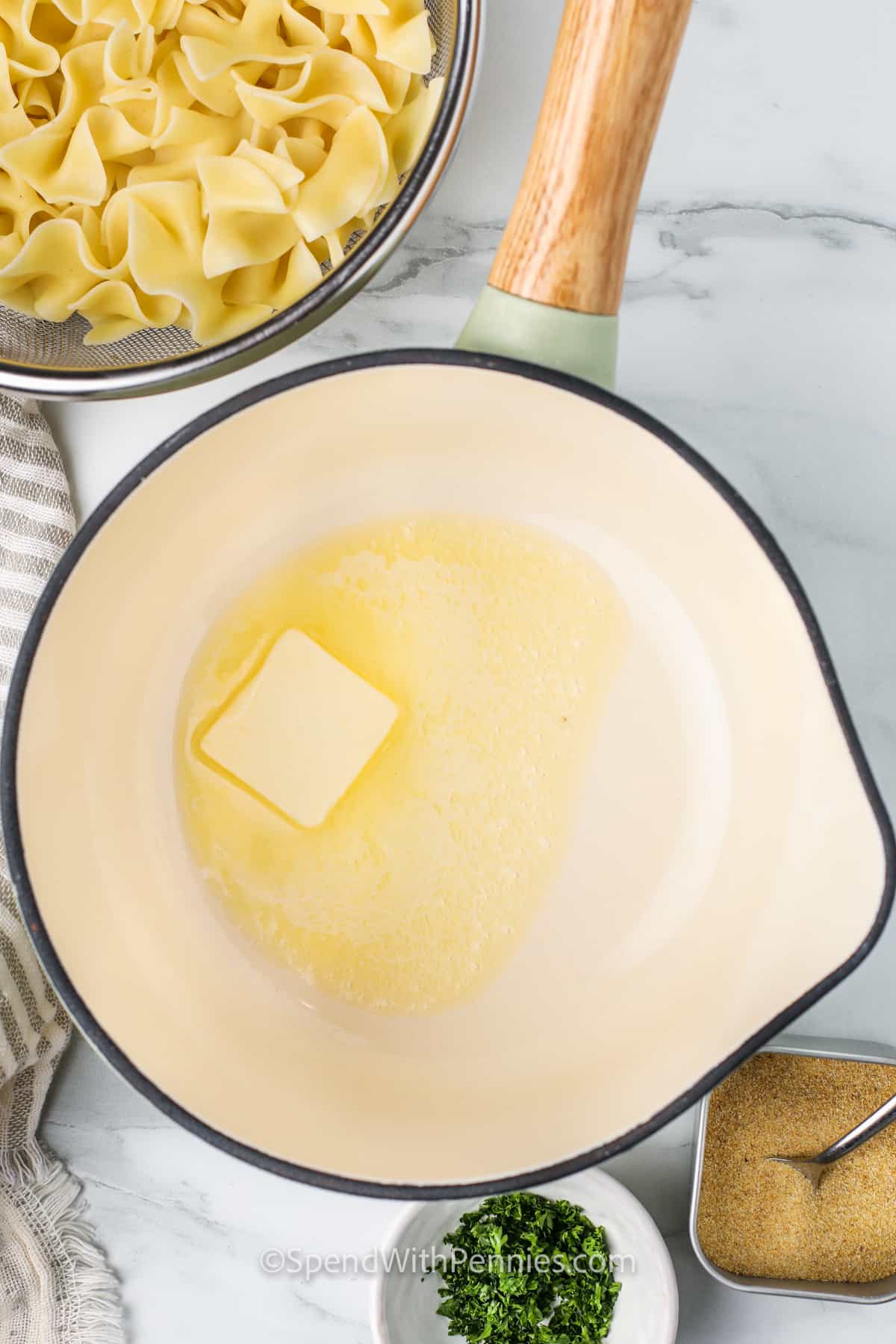 Buttered noodles are a warm and comforting pasta dish that’s as easy to make as it is delicious. Egg noodles are tossed with melted butter, garlic powder, and fresh parsley, then topped with a sprinkle of Parmesan for an extra touch. This homemade stovetop recipe is quick to season and makes one of the best side dishes for busy weeknights or cozy, simple dinners. #spendwithpennies melting butter to make Buttered Noodles