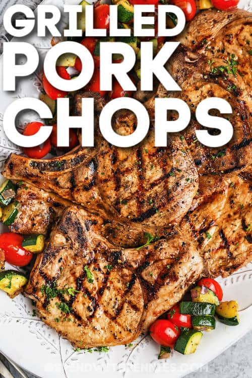 It doesn't take long to cook this easy recipe for grilled pork chops. Tender and juicy boneless loin chops are hot off the grill in no time, ready for serving with all your favorite summer side dishes. Try the tasty marinade, and enjoy all the flavors of summer grilling! #grilledporkchops #boneless #bestgrilledporkchopsrecipe #spendwithpennies plated Grilled Pork Chops with writing