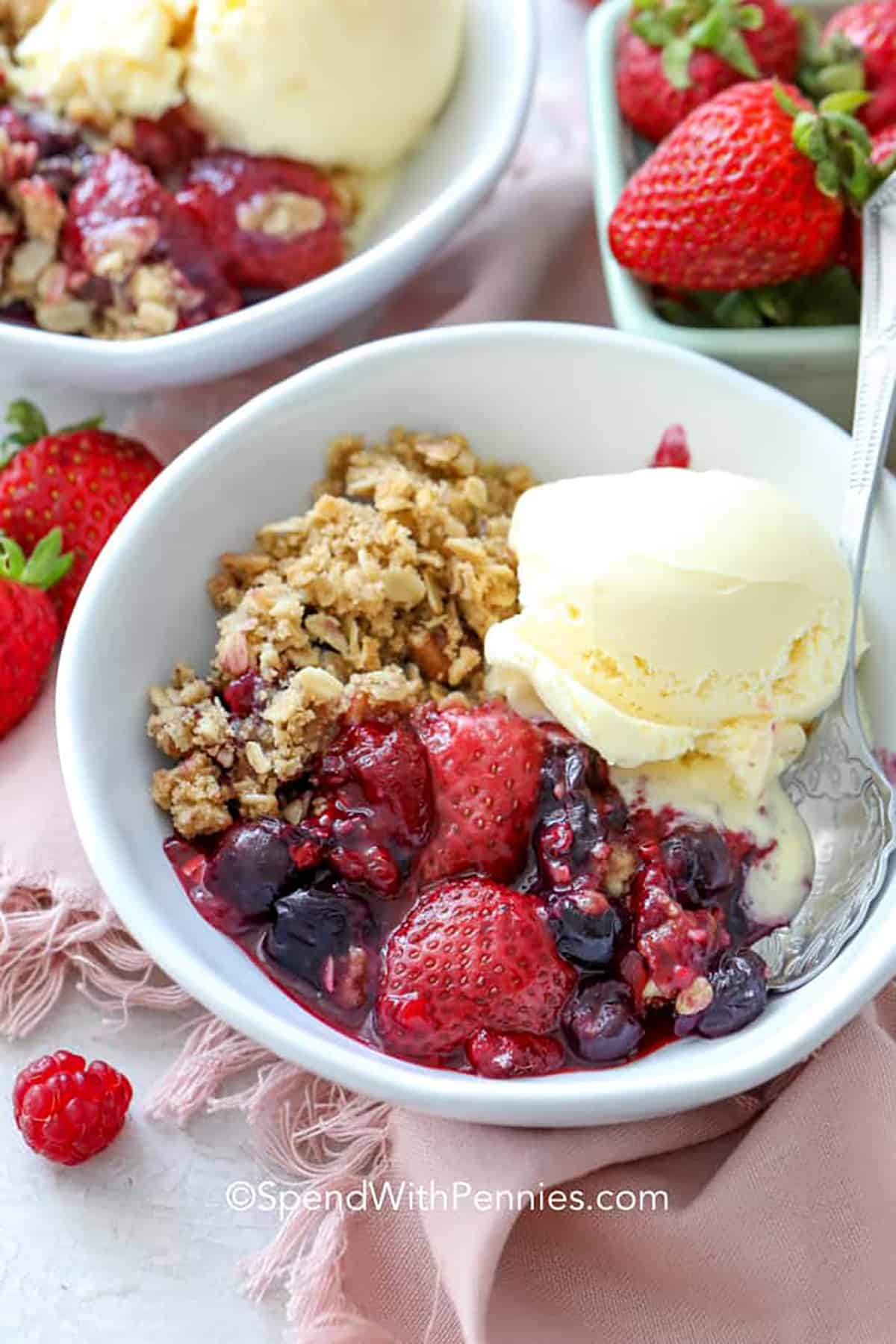 Mixed berry crisp is a dessert we always make, any time of year. It's a simple and delightful treat that combines fresh or frozen strawberries, blueberries, and raspberries. The best part is that it's incredibly easy to make so you can enjoy this homemade dessert in no time at all, without any hassle. Don’t forget the scoop of vanilla ice cream! #mixedberrycrisp #berrycrisp #dessert #homemade #spendwithpennies Mixed Berry Crisp in bowls