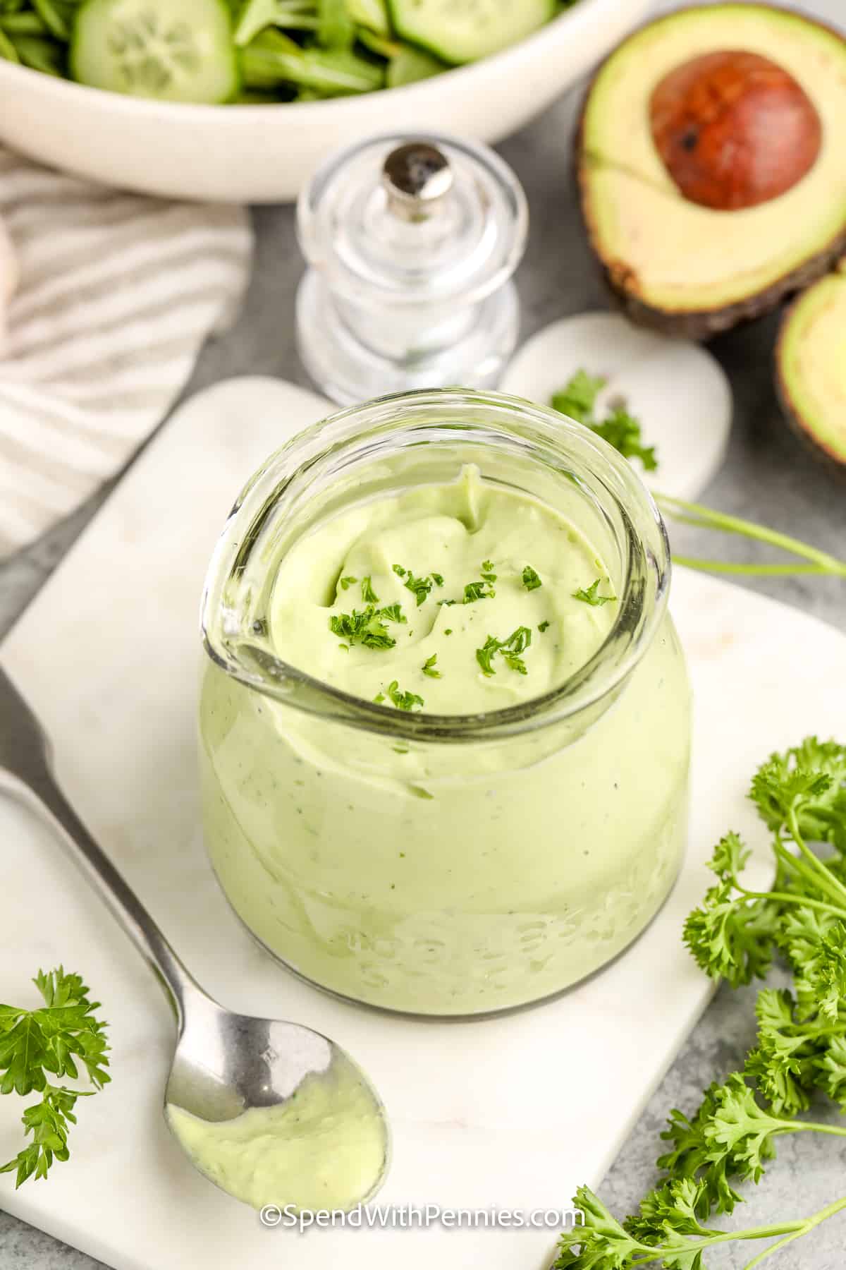 Try a new twist for topping salad with this easy to make avocado lime dressing recipe. The ingredients for this dressing are so simple - an avocado, yogurt, lime juice, milk, and a couple of spices. Just mix them together in a food processor, and this creamy dressing can be used to top a chicken salad, or added to a black bean quinoa bowl. The options are endless. #avocadolimedressing #dressing #saladdressing #limeavocadodressing #spendwithpennies jar of avocado lime dressing