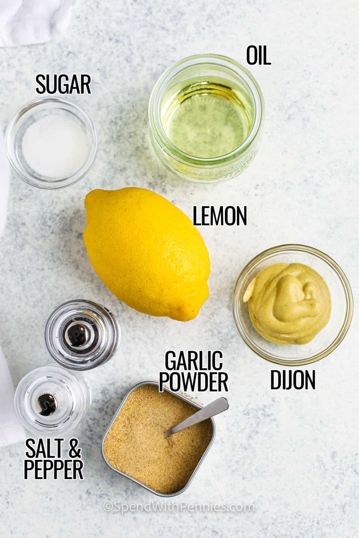Perfect for dressing salads, this dijon vinaigrette dressing is versatile. Drizzle this tangy vinaigrette over roasted veggies, or toss it into roasted sweet potatoes. Try mixing it into sour cream for a festive, savory dip, or have it with some low-carb crispy kale chips. It’s even great as a light dressing for pasta and seafood, or as a marinade for steaks or chops! #dijonvinaigrette #homemadevinaigretterecipe #easydressingrecipes #spendwithpennies sugar , oil , lemon dijon , garlic powder , salt and pepper with labels to make Easy Dijon Vinaigrette