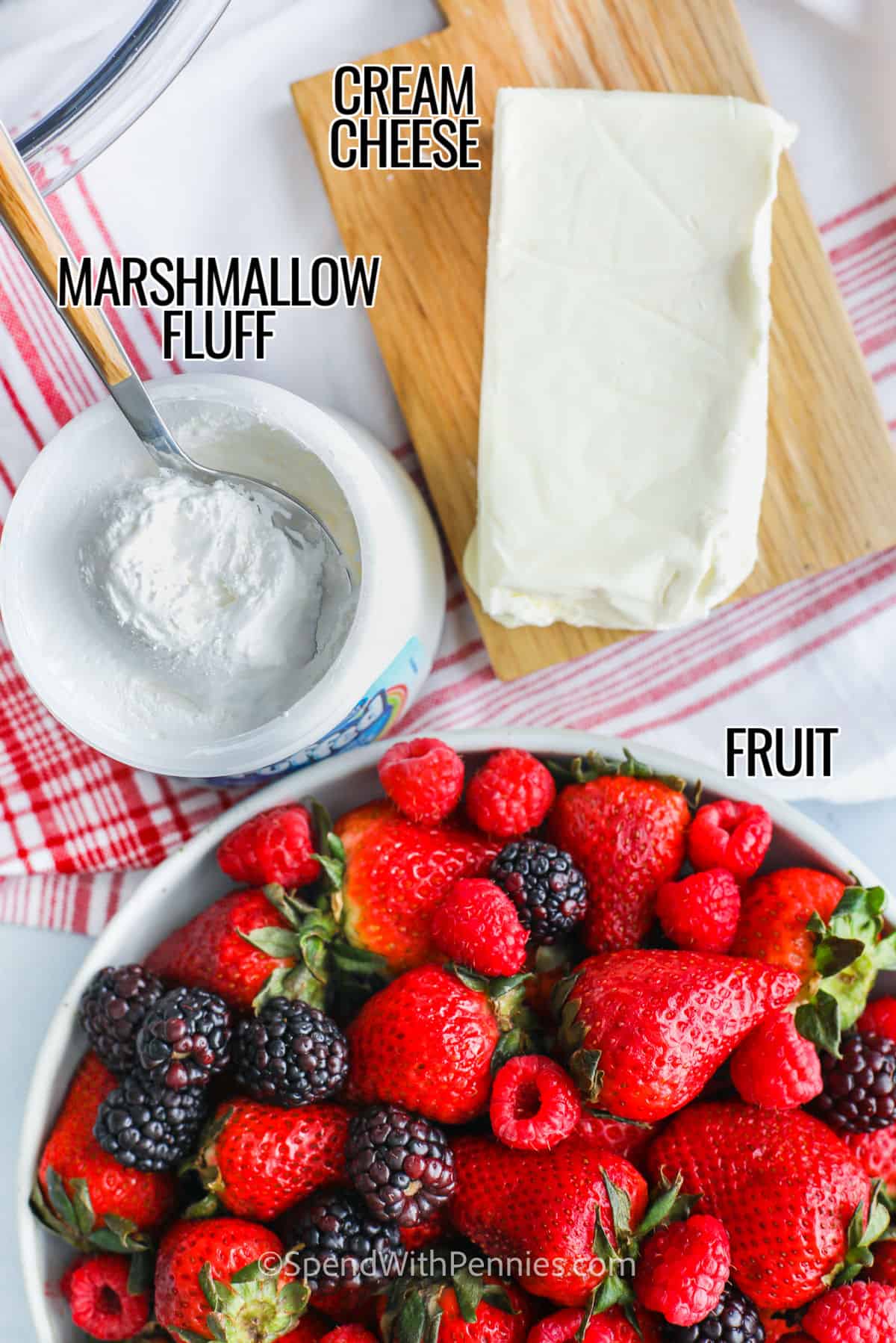 Experience the magic of a two-ingredient fruit dip that transforms ordinary fruits into extraordinary treats. With just a few ingredients, you can create a delicious dip that everyone will love. Serve with fruit, cookies or waffles for a delicious party snack! #fruitdip #2ingredientfruitdip #dessert #dip #spendwithpennies Cream cheese, marshmallow flakes and fruit with fruit dip labels
