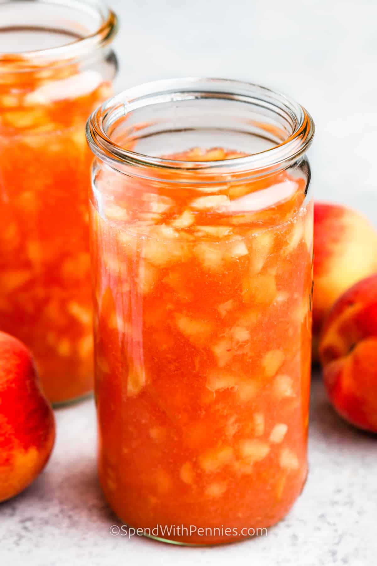 You can easily make peach jam with this simple freezer jam recipe. Enjoy the deliciousness of summer peaches throughout the year! It's quick to prepare - just peel, remove the pits, and mash the peaches. Mix in pectin, sugar, and a little lemon juice. Freeze or refrigerate for a few weeks. #peachjam #freezerjam #peachfreezerjam #spendwithpennies jar of Peach Freezer Jam