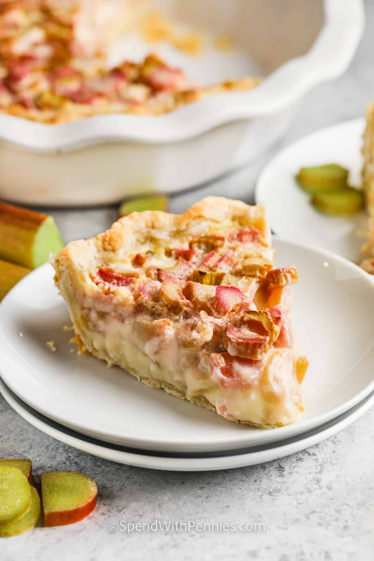 Try this delightful rhubarb custard pie for a perfect blend of tangy and creamy flavors! Fresh or frozen rhubarb pieces are nestled in a velvety homemade vanilla custard, all encased in a buttery pie crust. For an extra fruity twist, consider adding strawberries or chopped apples. Top it off with whipped cream or meringue for a delicious treat! #rhubarbcustardpie #rhubarbcustardpierecipe #spendwithpennies #rhubarbcustardpieeasy slice of Rhubarb Custard Pie