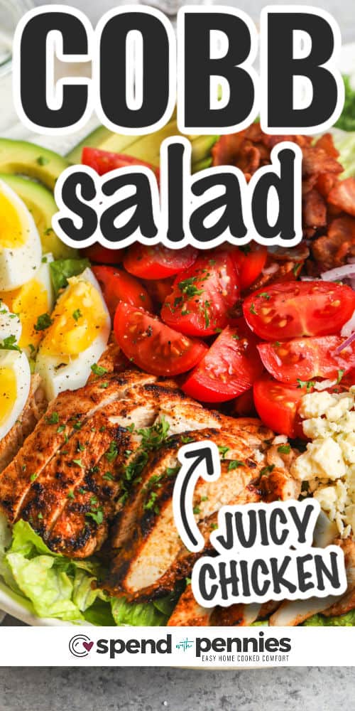 Cobb salad is easy to make and so delicious. This salad doubles as a full meal deal with chicken and cheese, romaine lettuce, avocado, eggs, and tomatoes in a creamy homemade dressing. Don't forget the bacon, for even more flavor! This satisfying salad is always a favorite whether served for lunch or as a light dinner-time entree. #cobbsalad #cobbsaladrecipe #salad #recipe #spendwithpennies close up of cobb salad with writing