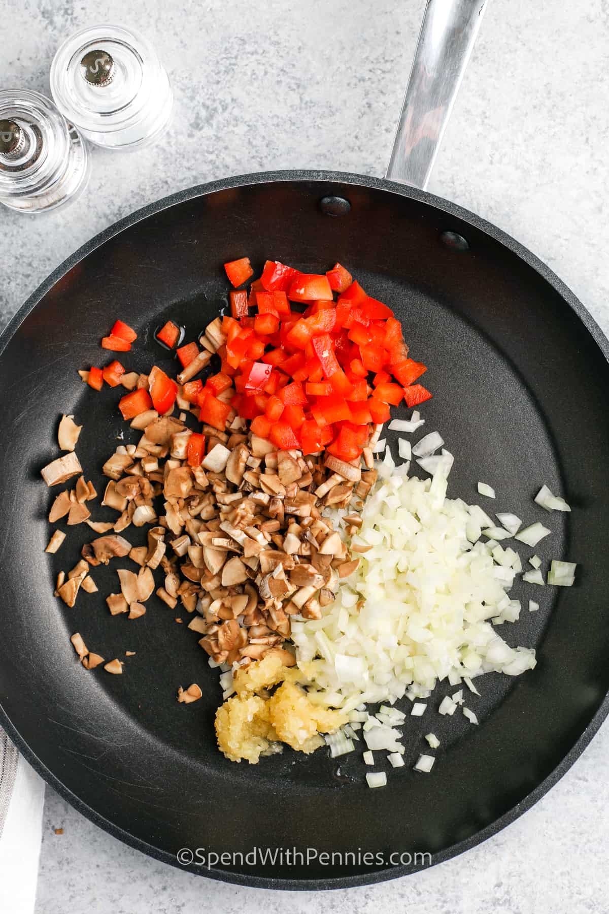 mushrooms, onions, peppers & garlic in a frying pan for Stuffed Portobello Mushrooms