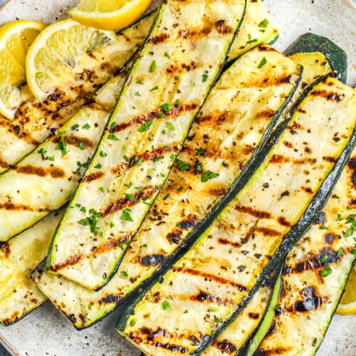 a plate of grilled zucchini with lemon slices