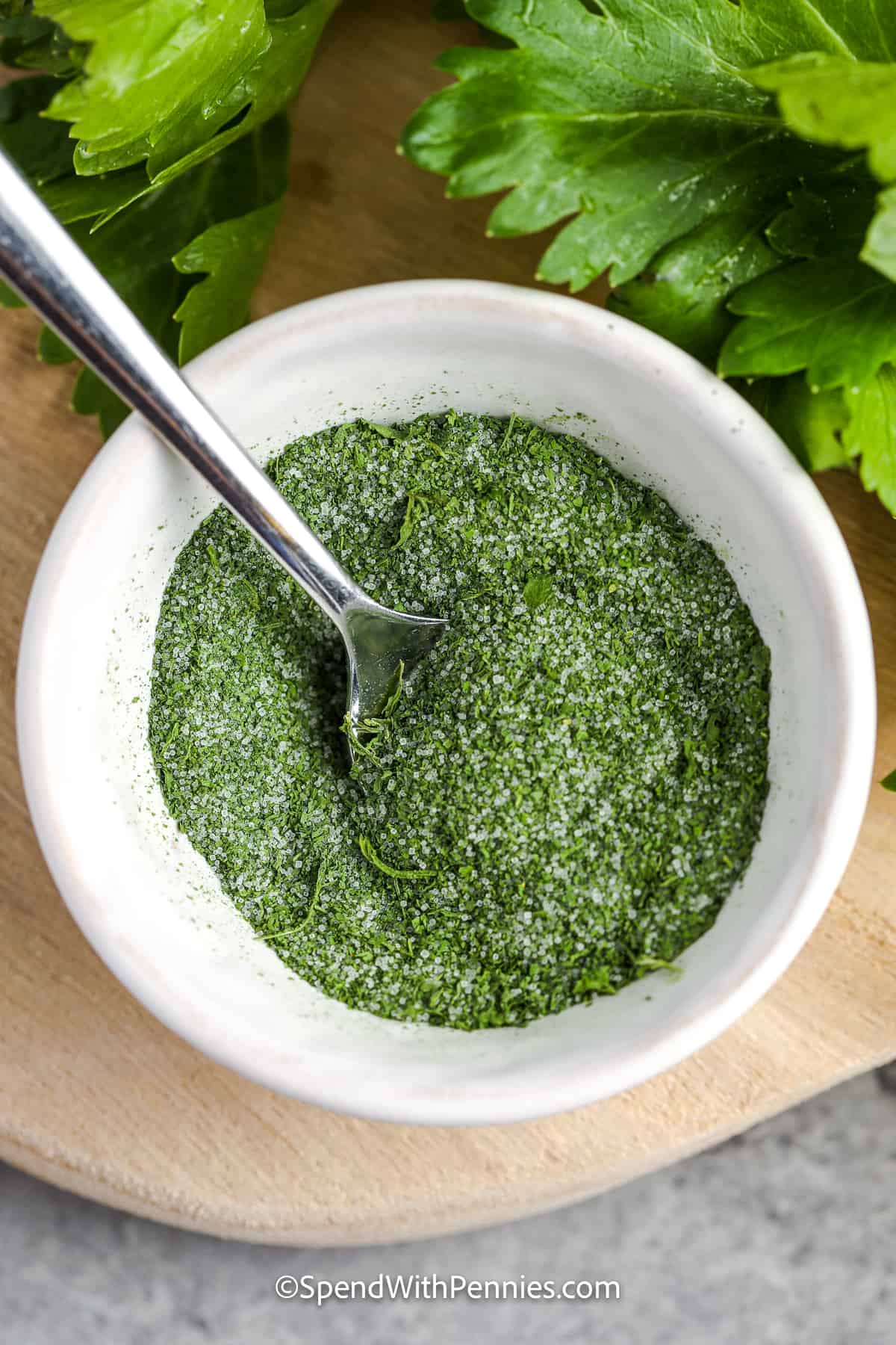 Make this DIY celery salt recipe to use in all your favorite recipes, from soups and salads, to sandwiches and entrees. Homemade celery salt is a great way to use up the celery leaves on stalks of fresh celery, instead of letting them go to waste. This spice mix adds an extra layer of flavor to so many dishes, and it tastes great in a cocktail, too! #celerysalt #celerysaltdiy #homemade #spendwithpennies celery salt in a dish with a spoon