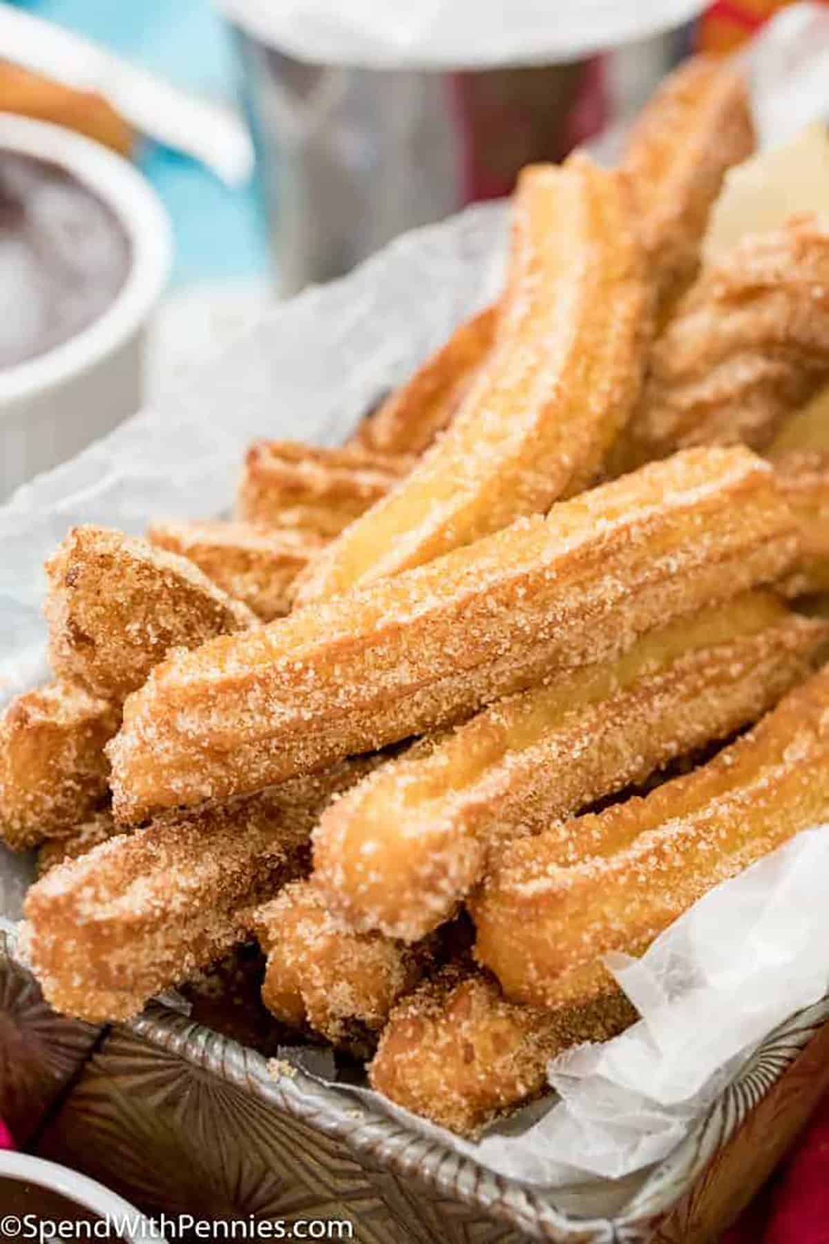 Homemade churros are golden, crispy pastries made from a simple dough, fried until perfectly golden, and coated in a sweet cinnamon-sugar mixture. With their crunchy exterior and soft, doughy interior, homemade churros are a delicious treat for anyone with a sweet tooth! #churros #homemade #recipe #mexican #spendwithpennies basket of Churros