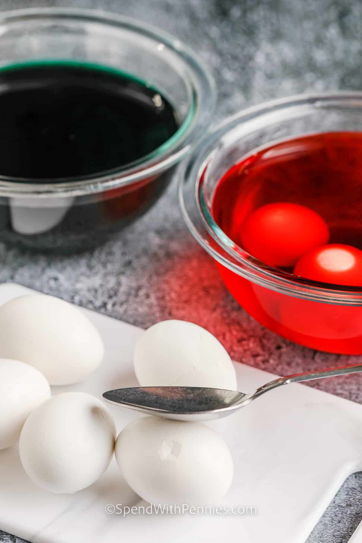 Halloween deviled eggs are a recipe that brings creepy-cute food to your party table. With marbled egg whites, scary eyeballs, or spider shapes on top, these are just right for costume night. They’re simple to make and even more fun to decorate with your own ideas, like pumpkin faces or avocado toppings. They’re a festive way to add spooky eye-catching flair to your Halloween celebration. #spendwithpennies cracking eggs and adding to food coloring to make Halloween Deviled Eggs