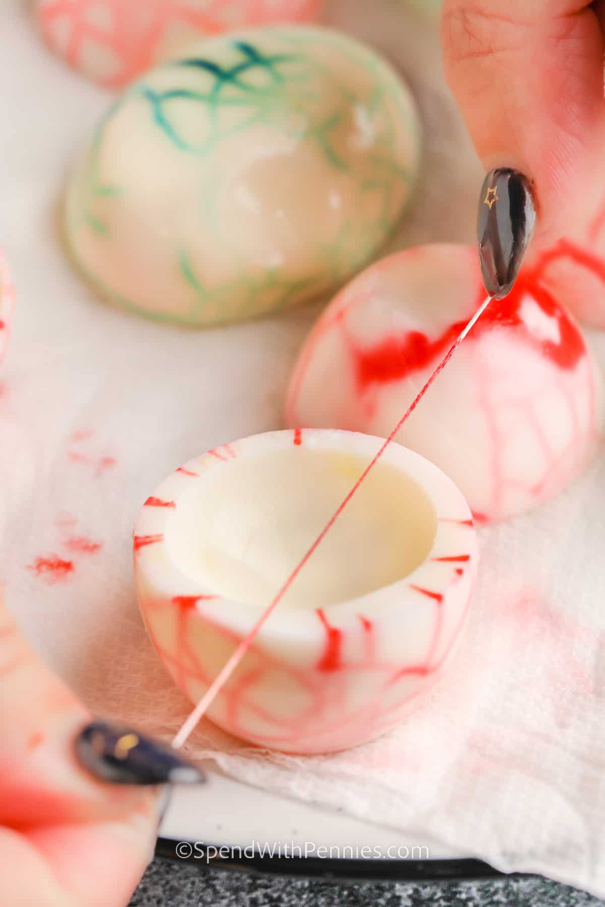 Halloween deviled eggs are the perfect recipe to make for spooky gatherings. The whites are cleverly marbled for a dramatic effect, and the creamy yolk fillings become the base for eyeball or spider decorations that will get a giggle out of everyone. They’re also easy to decorate with pumpkin shapes, avocado accents, or your own ideas. Fun to make and share, these creepy treats add frightful flair to any Halloween table! #spendwithpennies adding food coloring to Halloween Deviled Eggs