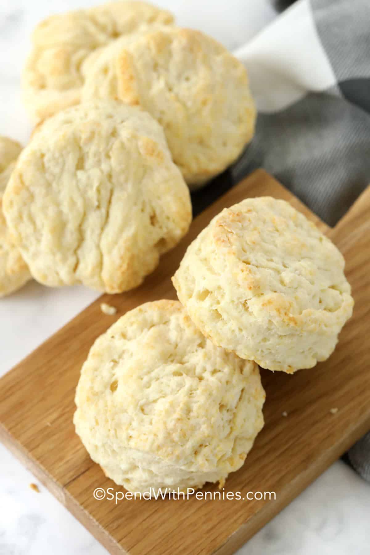 These easy homemade biscuits are made with flour, baking powder, cold butter, and milk for a classic biscuit recipe that works with sweet or savory meals. The texture is soft inside with lightly crisp, golden edges. They are budget-friendly, freezer-friendly, and perfect for serving warm from the oven with honey, jam, gravy, or your favorite comfort food dinner. #spendwithpennies A stack of homemade biscuits.