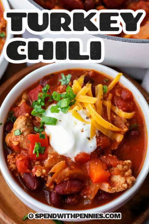 Serve this turkey chili for dinner tonight. Healthy ground turkey, tomatoes, broth, kidney beans, and seasonings are simmered in a pot on the stove or in a crock pot. This is such an easy and healthy main meal. Finish off the dish by serving it with some cheese, sour cream, or a little extra spice for added flavor! #turkeychili #turkeychilirecipe #groundturkey #spendwithpennies turkey chili in a bowl with writing