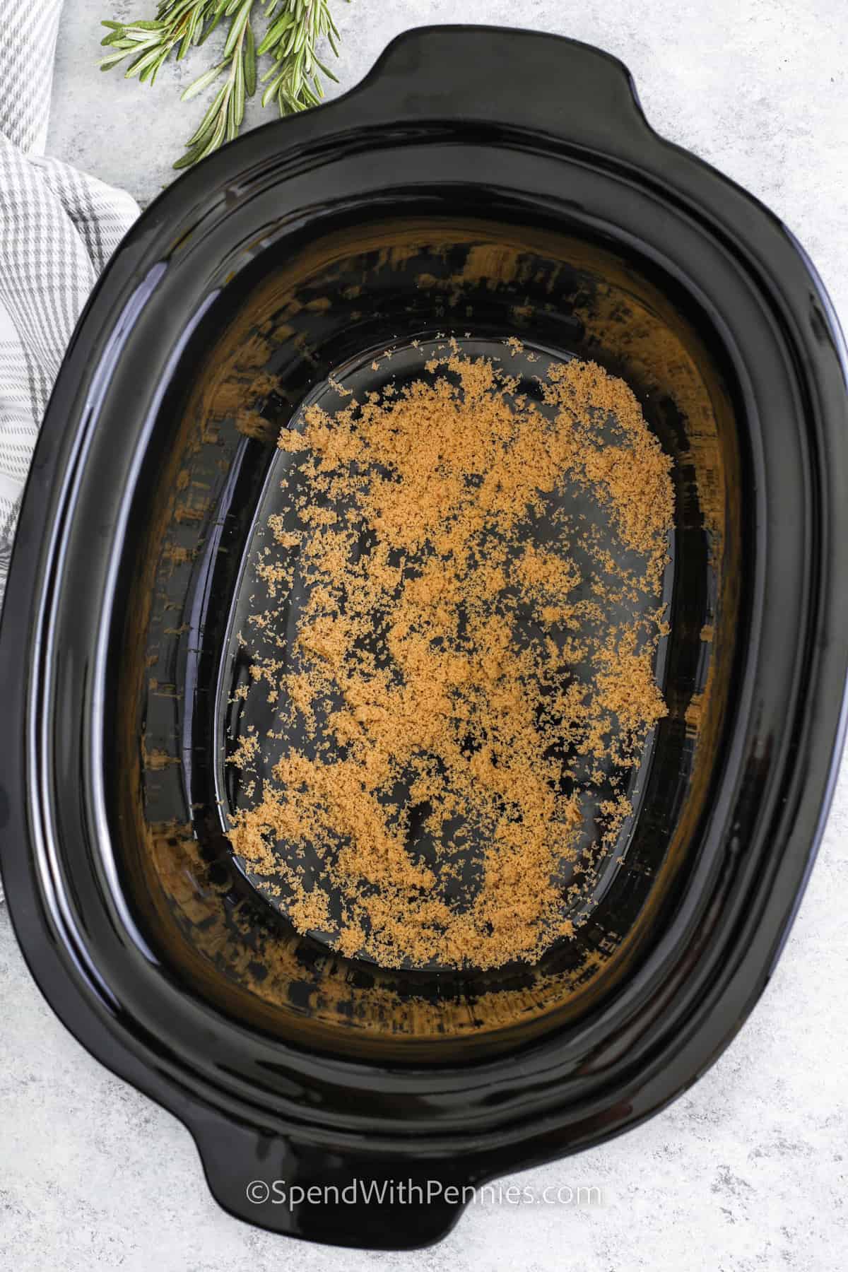 Crockpot ham is a perfect way to make a juicy, flavorful meal without standing over the oven. This spiral ham recipe uses a sweet glaze of brown sugar, apple preserves, Dijon mustard, and a touch of ginger to add depth. Cook in your slow cooker and optionally add rosemary for aroma. Pair it with roasted potato wedges, warm soup, or a side of baked beans for a complete comfort meal that the whole family will enjoy. #spendwithpennies adding ingredients to crock pot to make Crock Pot Ham