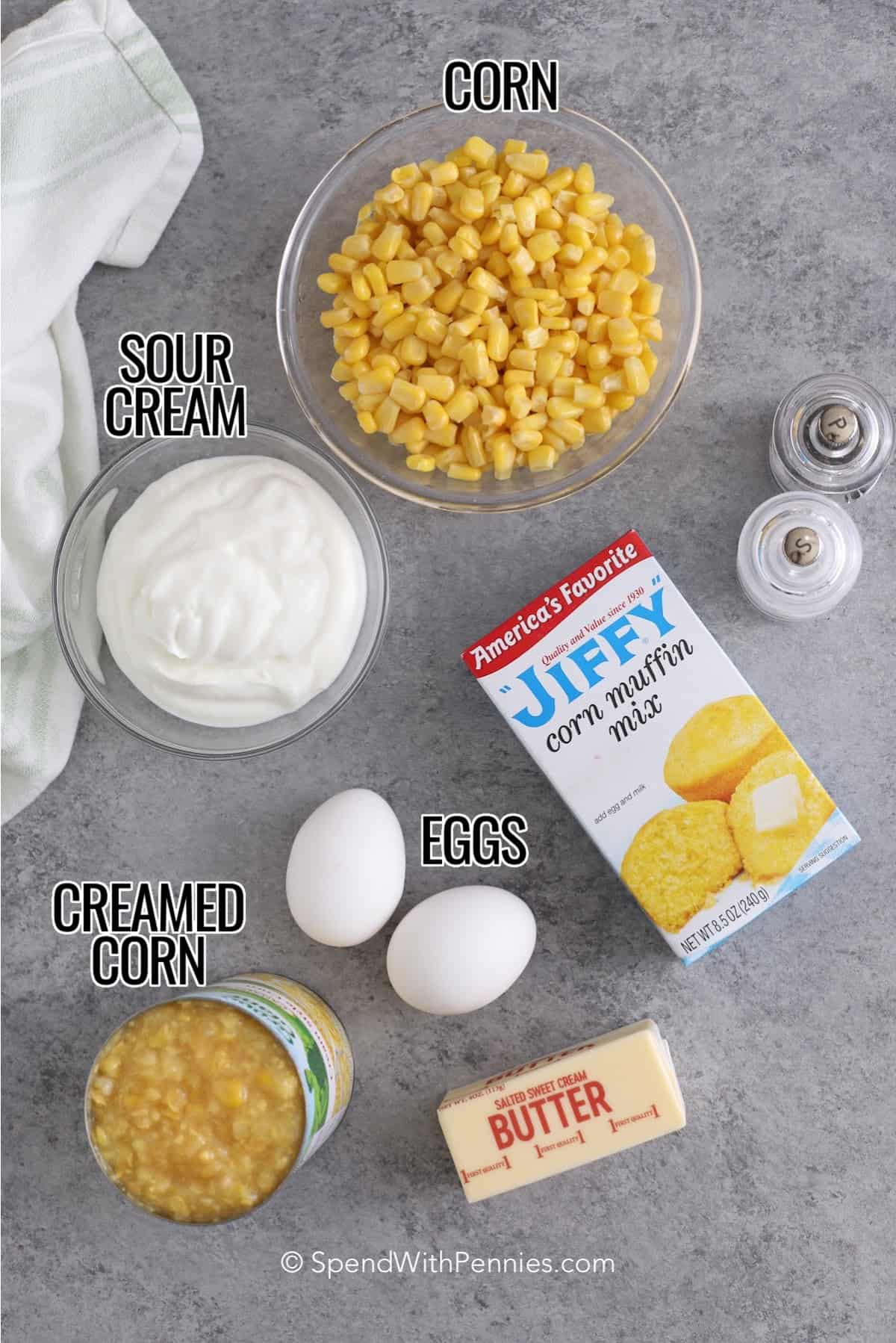 ingredients to make corn casserole including corn, sour cream, Jiffy corn muffin mix, eggs, butter, salt, pepper, and creamed corn