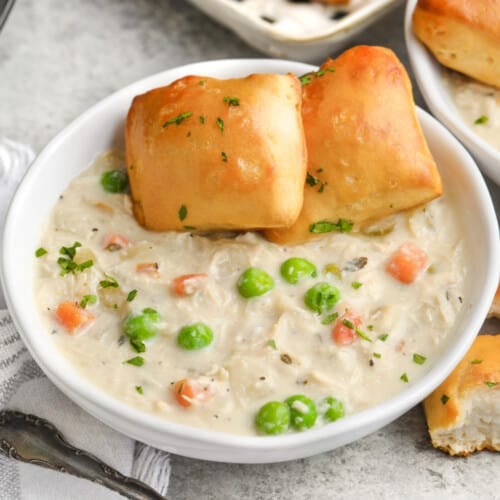 instant pot chicken pot pie soup in a bowl with buns