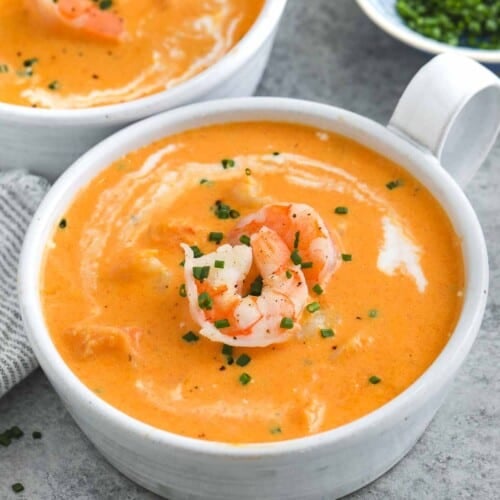 a bowl of shrimp bisque with shrimp and chives on top