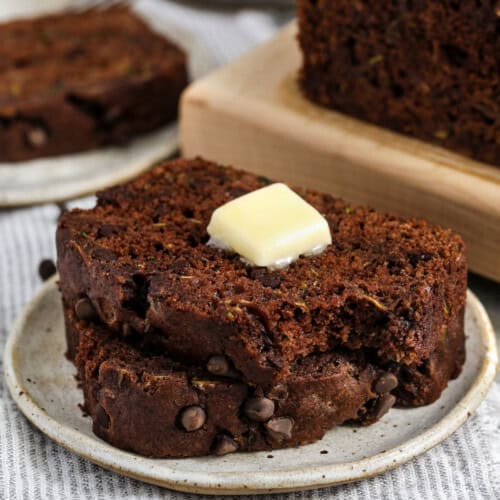slices of Chocolate Zucchini Bread on a plate with butter on top