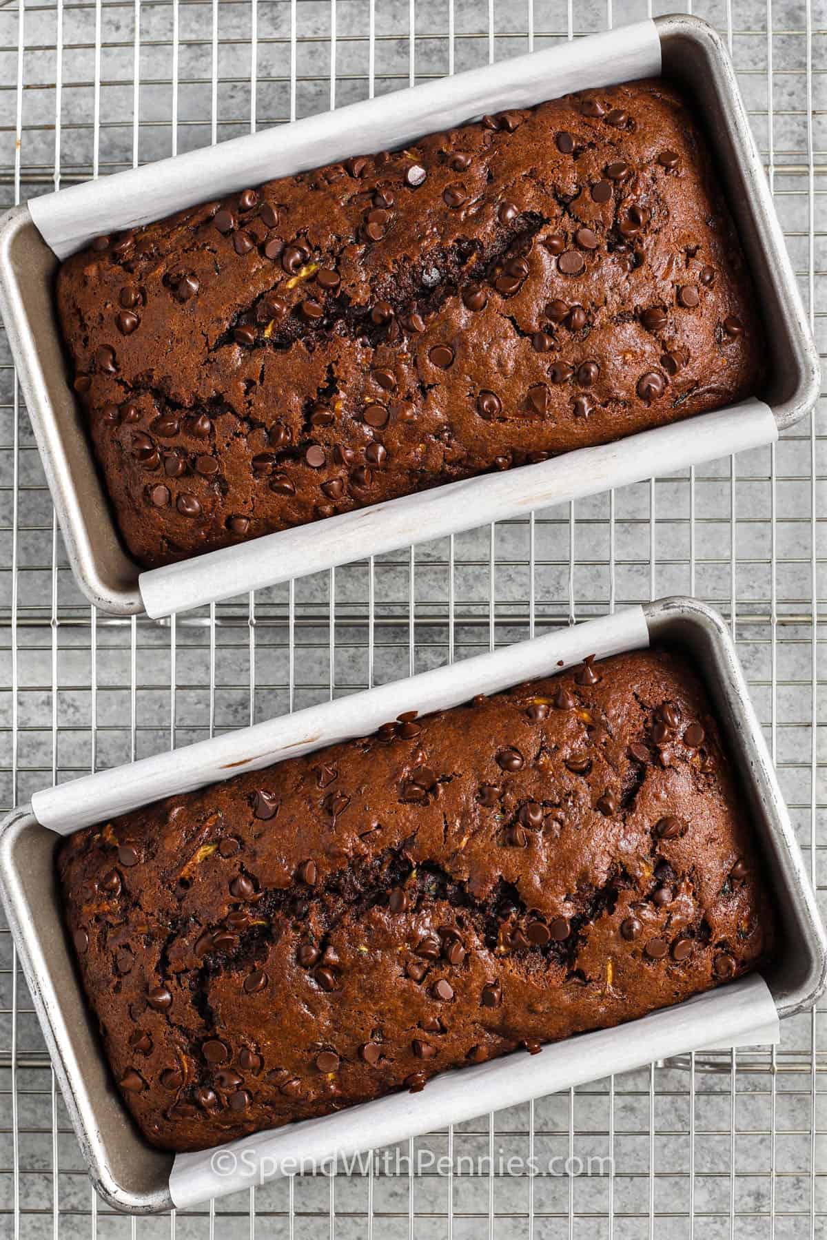 This chocolate zucchini bread is packed with chocolate chips and real cocoa for a double chocolate flavor. It’s soft and moist thanks to a bit of applesauce, and no one will believe it’s a healthy twist on a classic. This easy recipe is one of the best ways to use garden zucchini. For a little crunch, toss in chopped almonds or walnuts. It’s simple, homemade, and perfect anytime. #spendwithpennies pans of Chocolate Zucchini Bread on a cooling rack