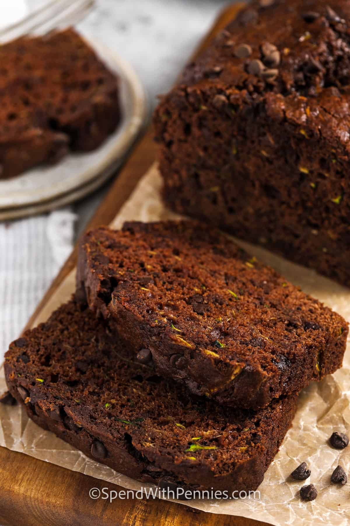 This chocolate zucchini bread recipe is the best way to use up fresh zucchini. It’s moist, rich, and packed with double chocolate flavor thanks to cocoa and mini chocolate chips. Applesauce keeps things light, so it’s a healthy treat you can feel good about. Want even more crunch? Add in some chopped almonds or walnuts for extra texture. This simple homemade loaf is one you’ll make again and again. #spendwithpennies loaf of Chocolate Zucchini Bread cut into slices
