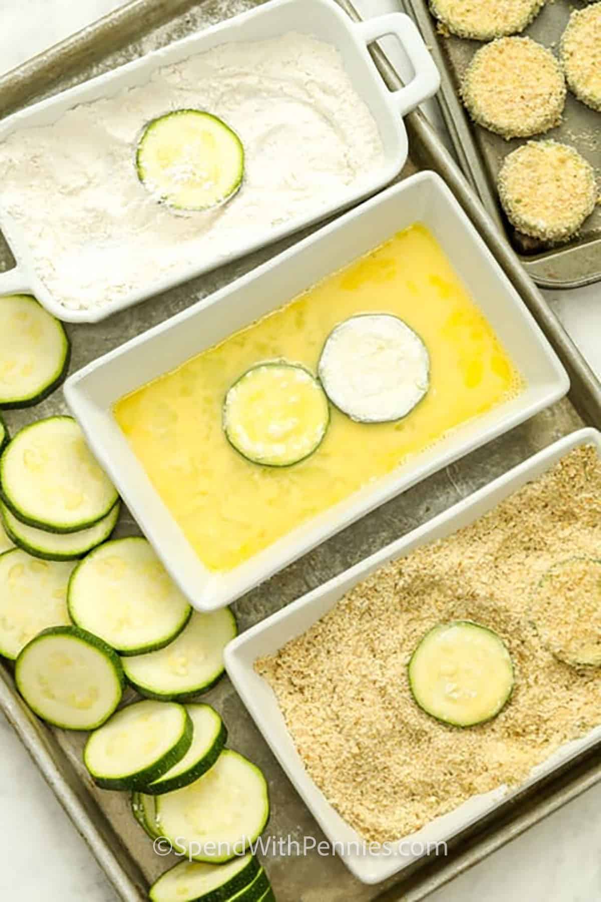 Oven fried zucchini gives you the same parmesan breadcrumb flavor with a simple baked method. Fresh zucchini rounds are coated, placed on a parchment-lined baking sheet, sprayed with cooking spray, and baked until golden. This Fried Zucchini variation is easy, flavorful, and perfect when you want a crispy vegetable side with less stovetop cleanup. #spendwithpennies Dipping the zucchini in flour, then the egg mixture, then pressing into the parmesan breadcrumb coating to make Crispy Fried Zucchini