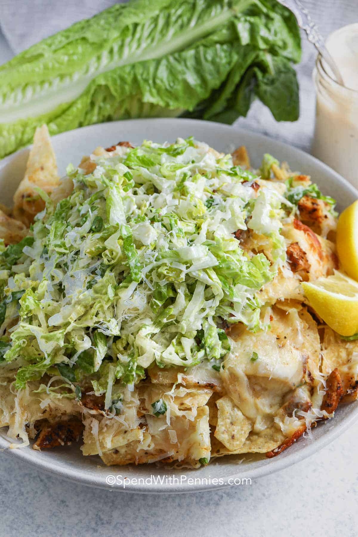 A bowl of nachos topped with shredded salad