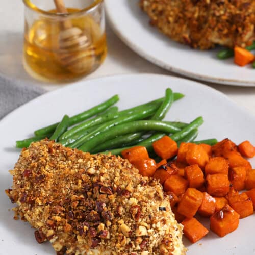 pecan crusted chicken with sweet potatoes and green beans on a plate