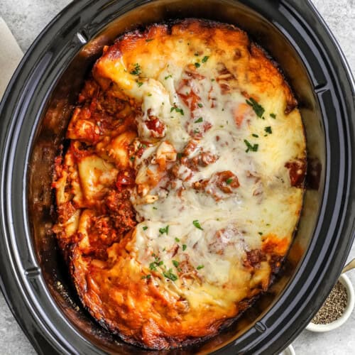 cheesy Crock Pot Lasagna with a portion taken out of the pot