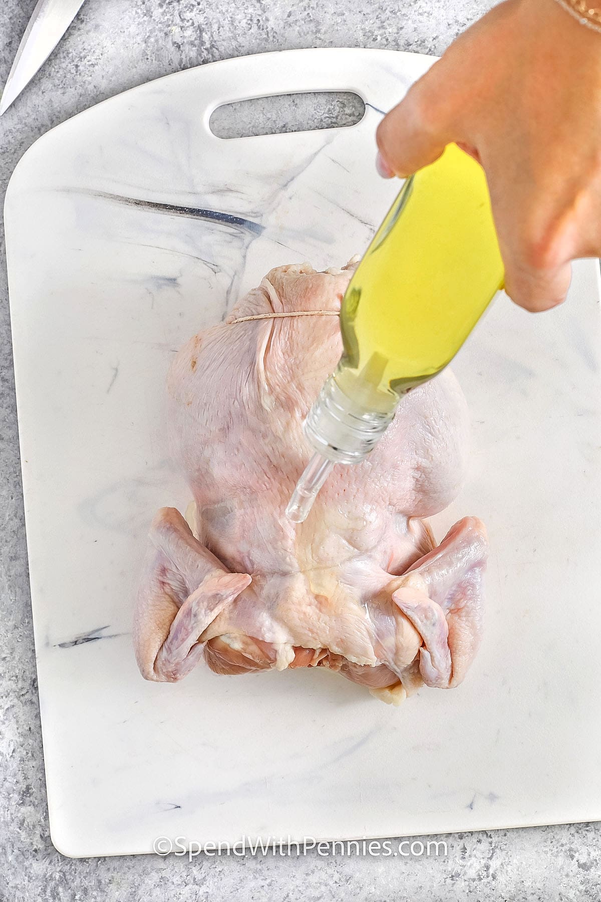 Roasting a whole chicken is a go-to recipe that’s both simple and satisfying. With just a little oil and seasoning, you’ll achieve that perfectly crispy skin and juicy meat. Stuffing the cavity with an onion adds a subtle flavor, and trussing the legs helps it cook evenly. The real secret is letting the chicken rest before carving, which keeps every bite tender and delicious. It’s a comforting meal that fills the house with amazing aromas and always brings everyone to the table! #spendwithpennies adding oil to chicken to show How to Prepare a Whole Chicken