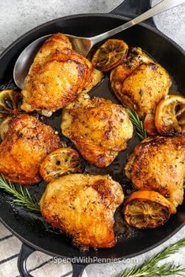 skillet of Skillet Chicken Thighs with one on a spoon