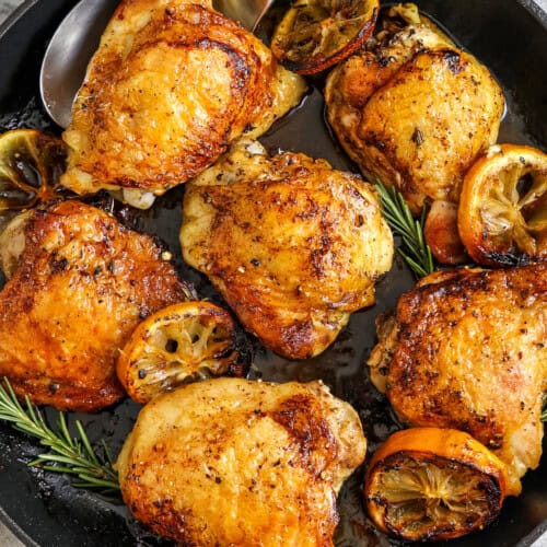 skillet of Skillet Chicken Thighs with one on a spoon