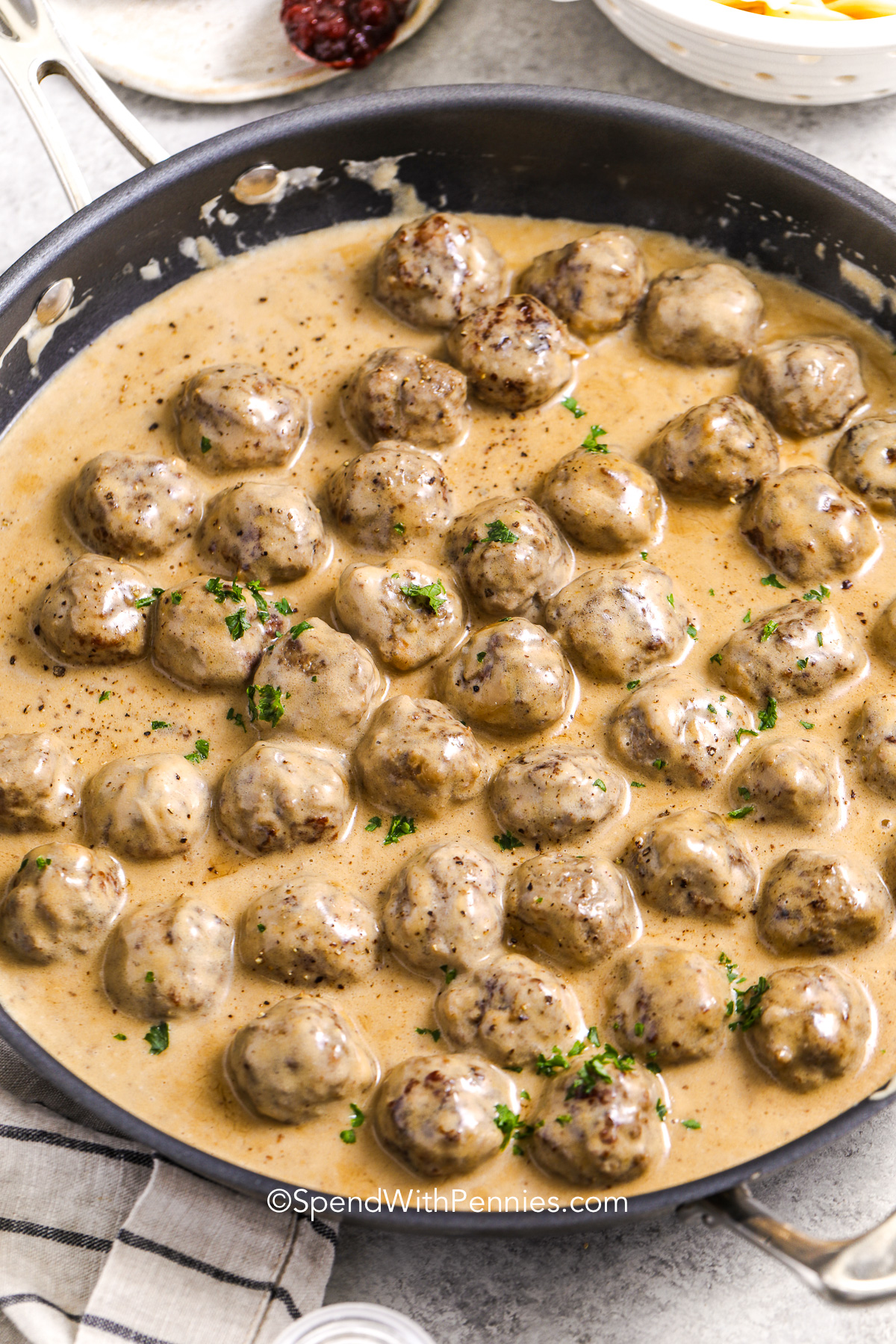 a skillet of cooked Swedish meatballs in sauce