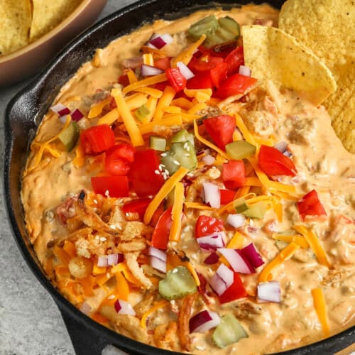 Cheeseburger Dip with toppings and tortilla chips