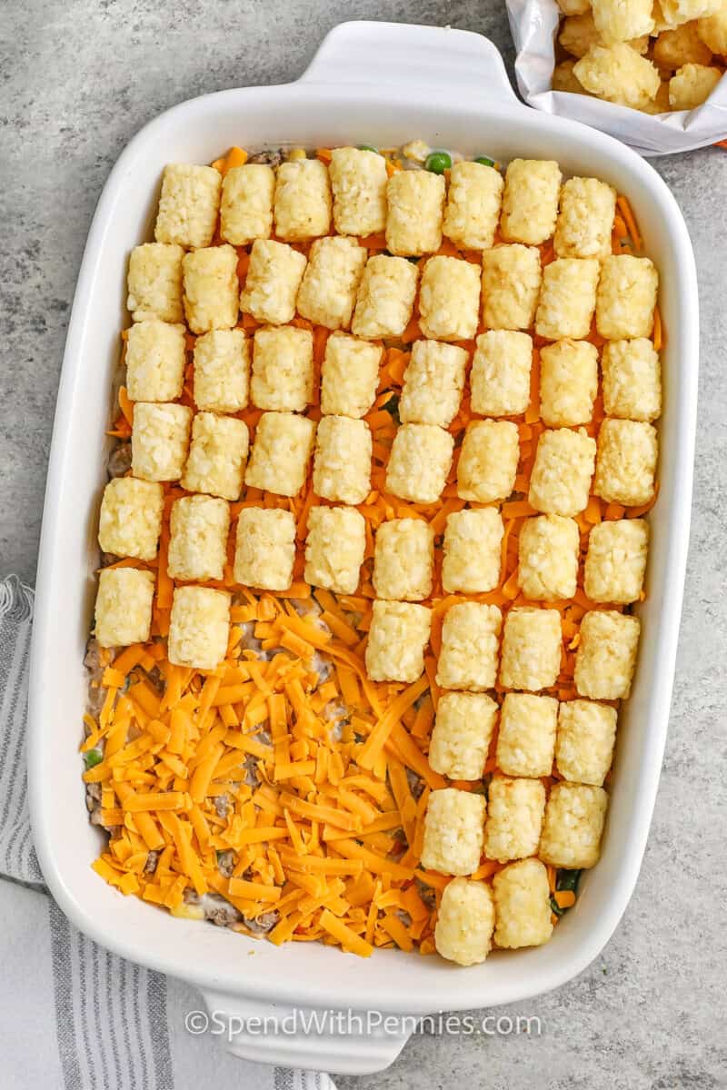 adding cheese then tater tots to dish to make Classic Tater Tot Casserole