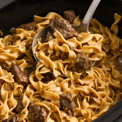 taking a spoonfull of Crock Pot Beef and Noodles out of the pot